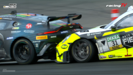 Two race cars race side by side on a track, one blue/gray with colorful sponsor decals and the other neon yellow with many sponsor stickers.