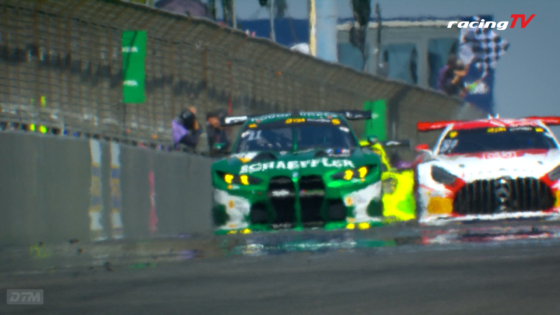 Green race car moving along the track near a pit wall, with blurred background and RacingTV logo in the top right.